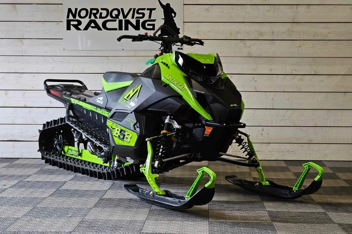Arctic Cat-skoter framför Nordqvist Racing-skylten